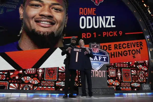 Washington wide receiver Rome Odunze, left, poses with NFL Commissioner Roger Goodell after being chosen by the Chicago Bears with the ninth overall pick during the first round of the NFL football draft, Thursday, April 25, 2024, in Detroit. (AP Photo/Jeff Roberson)