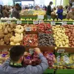 An employee arranges a digital price tag for vegetables at the Whole Foods store in the Silver Lake neighborhood of Los Angeles.