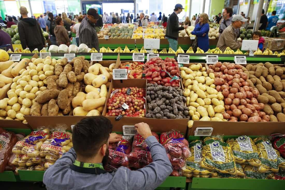 An employee arranges a digital price tag for vegetables at the Whole Foods store in the Silver Lake neighborhood of Los Angeles.